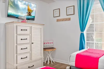a bedroom with a dresser and a tv on the wall at Fabulous Condo at World Quest Resort Disney area in Orlando