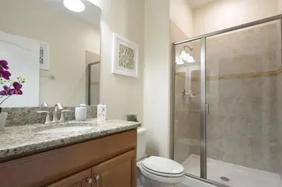 a bathroom with a shower and a toilet and a sink at Casa de 4 Quartos com Piscina Privativa in Kissimmee