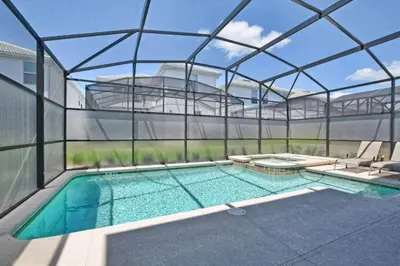 a glass house with a swimming pool and chairs at Casa 6 Quartos | Piscina Privativa | 10min Disney! in Kissimmee