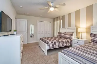 a bedroom with two beds and a ceiling fan at Casa 6 Quartos | Piscina Privativa | 10min Disney! in Kissimmee