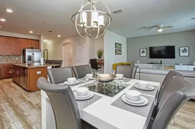 a dining room and kitchen with a table and chairs at Casa 6 Quartos | Piscina Privativa | 10min Disney! in Kissimmee