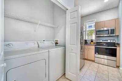 a white kitchen with a dishwasher and a stove at Stylish Townhome Close to Disney Parks in Kissimmee