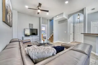 a living room with a couch and a tv at Stylish Townhome Close to Disney Parks in Kissimmee