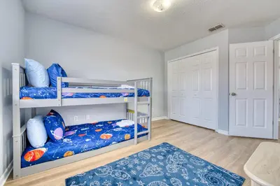 a bedroom with two bunk beds and a rug at Stylish Townhome Close to Disney Parks in Kissimmee