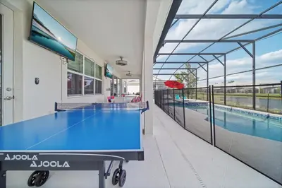 a ping pong table in a room with a swimming pool at The Bling Estate in Kissimmee