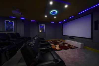 a living room with a couch and a big screen tv at The Bling Estate in Kissimmee