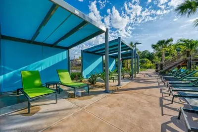 a row of green chairs and a blue building at Casa 5Q/5B c/ Piscina Perto da Disney in Kissimmee