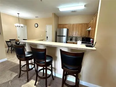 a kitchen with a counter and chairs in a room at 2 Bedrooms 2 Bathrooms Secret Lake 3176-204 in Kissimmee