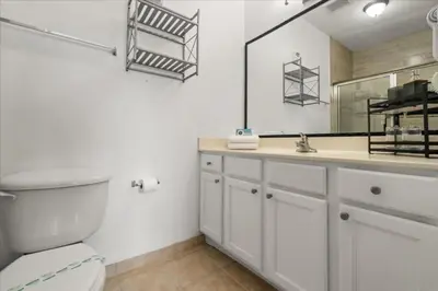 a bathroom with a toilet and a sink and a mirror at 2 Bedrooms 2 Bathrooms Secret Lake 3176-204 in Kissimmee