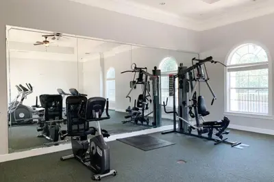 a gym with several tread machines and a large mirror at 2 Bedrooms 2 Bathrooms Secret Lake 3176-204 in Kissimmee