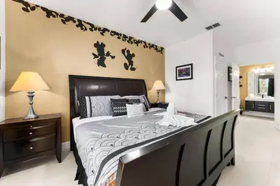 a bedroom with a large bed with a wooden headboard at Windsor Palms Mickey Themed Condo, Pool, By Disney in Kissimmee
