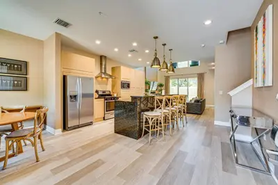 a kitchen and dining room with a bar with stools at Less Than 2 Mi to WDW Attractions Luxe Family Getaway! in Orlando
