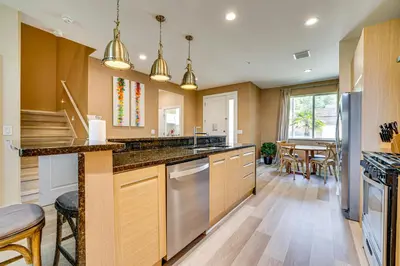 a kitchen with wooden cabinets and stainless steel appliances at Less Than 2 Mi to WDW Attractions Luxe Family Getaway! in Orlando
