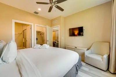 a bedroom with a large white bed and a chair at Less Than 2 Mi to WDW Attractions Luxe Family Getaway! in Orlando