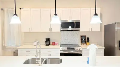 a kitchen with white cabinets and stainless steel appliances at Entire House in Orlando close to All Parks in Orlando