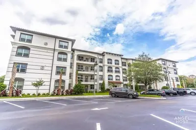 an apartment building with cars parked in a parking lot at Vista Cay Resort in Orlando