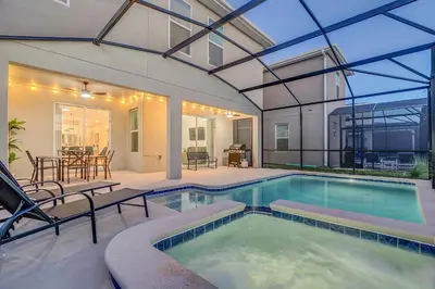 a swimming pool with a patio and a house at Disney Nearby! Private Pool, Movie Theater & Themed Rooms – Storey Lake Resort! in Kissimmee