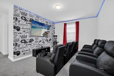 a waiting room with black chairs and a flat screen tv at Disney Nearby! Private Pool, Movie Theater & Themed Rooms – Storey Lake Resort! in Kissimmee