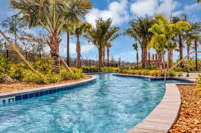 a pool with palm trees and a slide at Dream Vacation Home – Private Pool, Themed Rooms & Resort Access – ChampionsGate! in Kissimmee