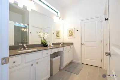 a white bathroom with a sink and a mirror at Brand New DLuxx Top Elegance Vacation Home 1018 in Orlando