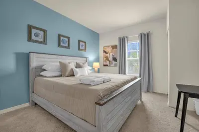 a bedroom with a large bed with blue walls at Dluxx Perfect Townhouse next to Disney Parks 3204 in Kissimmee
