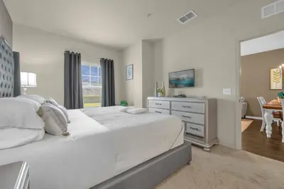 a bedroom with a bed and a dresser and a table at Dluxx Perfect Townhouse next to Disney Parks 3204 in Kissimmee