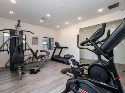 a gym with several exercise bikes and treadmills at Amazing 03 Bedrooms 03 Baths Sleeps 08 in Kissimmee