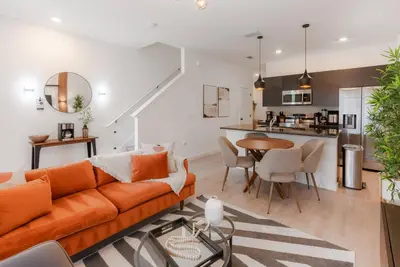 an open living room with an orange couch and a table at Amazing 03 Bedrooms 03 Baths Sleeps 08 in Kissimmee