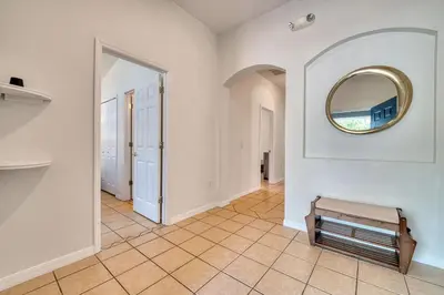 a hallway with a mirror on the wall and a bench at Private Pool Getaway Near Theme Parks in Kissimmee