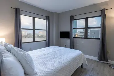 a bedroom with a white bed and two windows at Amazing 2 Bedrooms Nex to Universal in Orlando