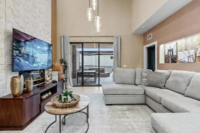 a living room with a couch and a tv at Home Luxury 4 BedsPrivate Hot Tub Close Disney in Orlando