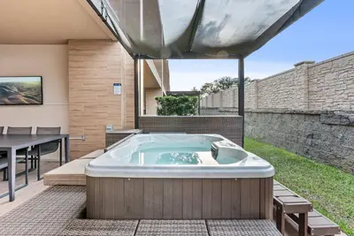 a jacuzzi tub in a backyard with a table at Home Luxury 4 BedsPrivate Hot Tub Close Disney in Orlando
