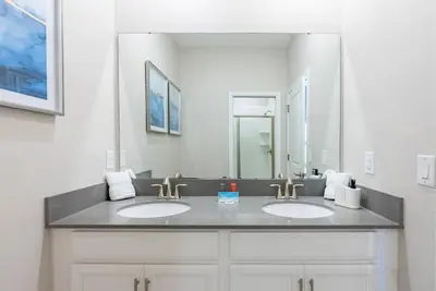 a bathroom with two sinks and a large mirror at Brand New 5 Bedrooms4 Baths At Storey Lake in Kissimmee