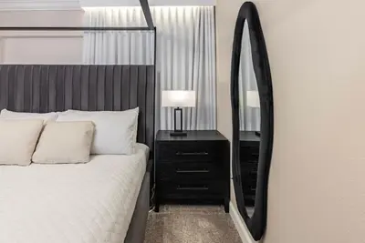 a bedroom with a bed and a large mirror at Brand New 5 Bedrooms4 Baths At Storey Lake in Kissimmee