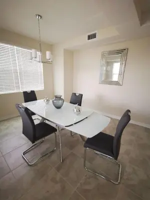 a dining room with a white table and chairs at Aqua Vista Storey Lake in Kissimmee