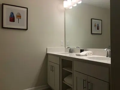 a bathroom with a sink and a large mirror at Aqua Vista Storey Lake in Kissimmee