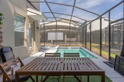 a swimming pool in a house with a wooden table at Brand New 5 Bedrooms5Baths At Storey Lake in Kissimmee