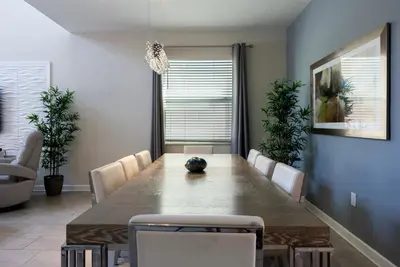 a dining room with a large table and chairs at Brand New 5 Bedrooms5Baths At Storey Lake in Kissimmee
