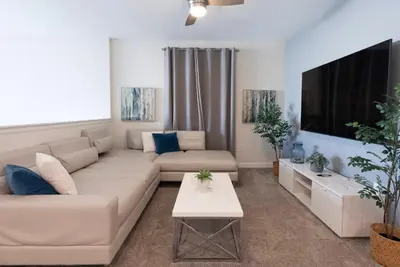 a living room with a couch and a tv at Brand New 5 Bedrooms5Baths At Storey Lake in Kissimmee