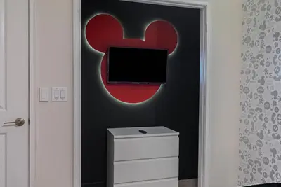 a bedroom with a red and black wall with a tv at NEW Cozy 2 Bedrooms2Baths At Storey Lake in Kissimmee