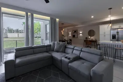 a living room with a couch and a kitchen at NEW Cozy 2 Bedrooms2Baths At Storey Lake in Kissimmee