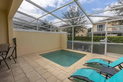 a patio with a swimming pool with a glass roof at Amazing 3 Bedrooms with Private Pool- Close to Disney in Orlando