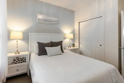 a bedroom with a large white bed with two lamps at Amazing 3 Bedrooms with Private Pool- Close to Disney in Orlando