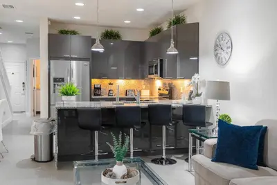 a kitchen with a bar with black bar stools at Amazing 3 Bedrooms with Private Pool- Close to Disney in Orlando