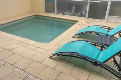 a swimming pool with two chairs and a blue poolvisor at Amazing 3 Bedrooms with Private Pool- Close to Disney in Orlando