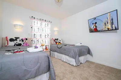 a bedroom with two beds and a tv on the wall at Charming Vacation Home 9 miles From Disney 1065 in Kissimmee