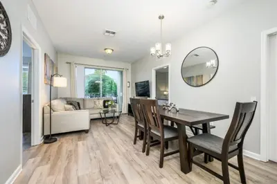 a dining room with a table and chairs and a mirror at Epic Universe New Listing Beautiful Vacation Condo - 3018 in Orlando