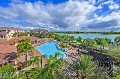 an aerial view of a pool at a resort with a lake at Epic Universe Vacation Condo, Vista Cay - 2017 in Orlando