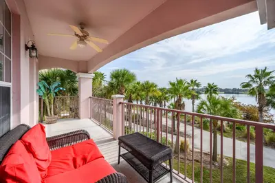 a porch with a couch and a view of the water at Epic Universe Premium Lake View Condo, Vista Cay - 1002 in Orlando