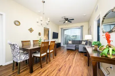 a dining room and living room with a table and chairs at Beautiful Deluxe Condo, Vista Cay - 3023 in Orlando